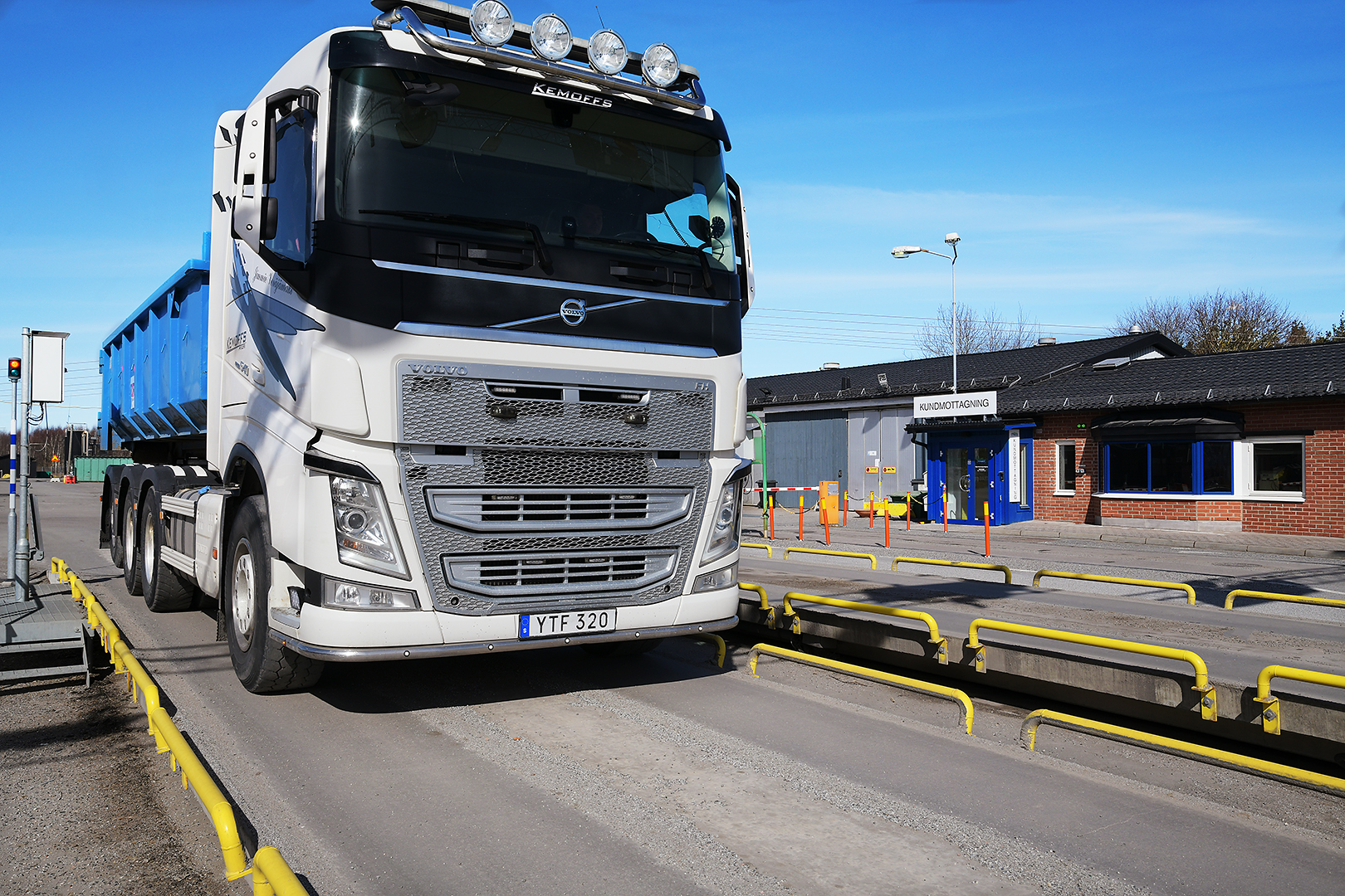 Stor lastbil på vågen med Hagbys kundmottagning i bakgrunden