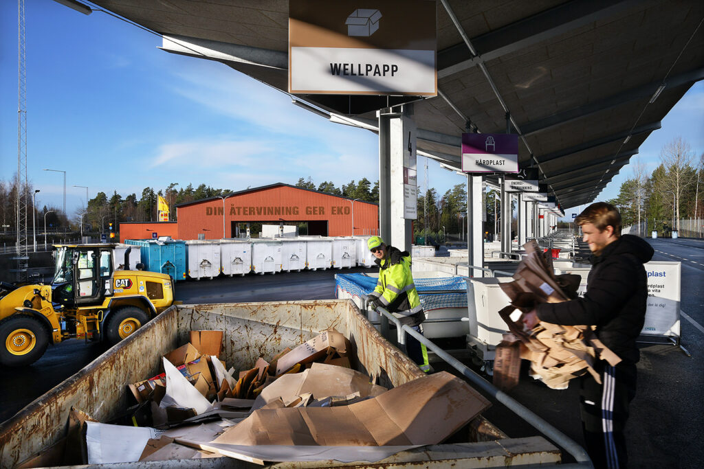 Man sorterar wellpapp på Vallentuna returpark