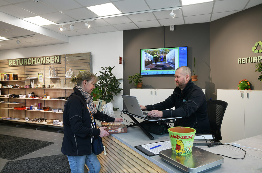 En kund får hjälp av personalen att väga materialet